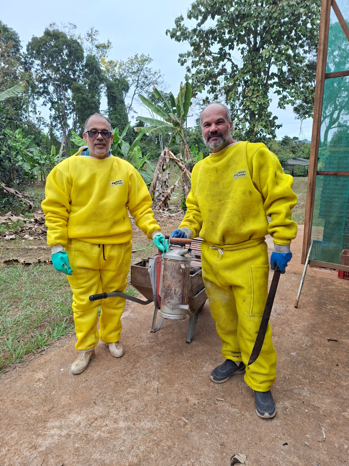 Ermes Marques Pedrosa e Ságuio Moreira com equipamento de apicultura durante revisão das colmeias do CTA
