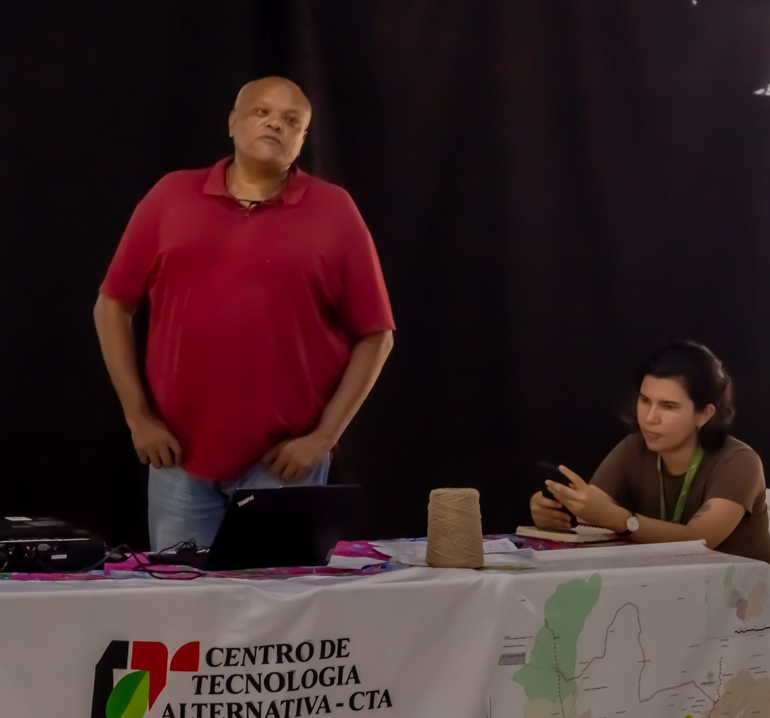 Selmo de Oliveira, de camisa vermelha, de pé, e Patrícia dos Santos Leite, sentada à mesa do CTA, durante a oficina da CONAB