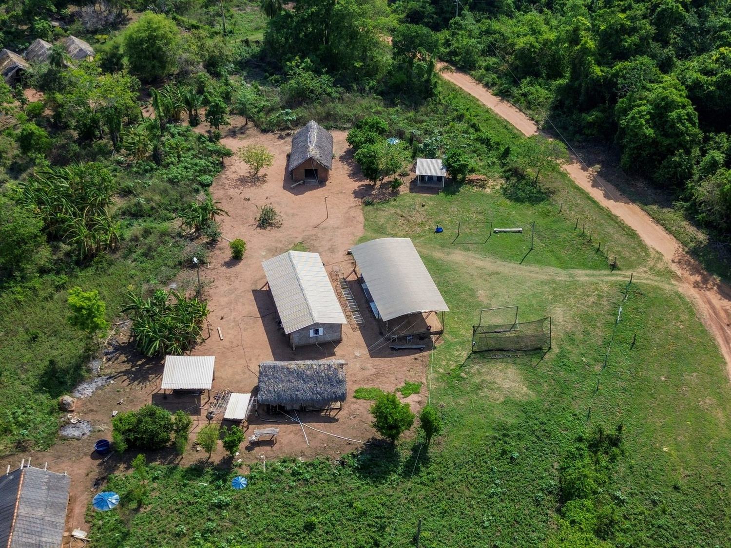 Vista aérea da Aldeia Fazendinha, com casas, salão comunitário e estrada de terra