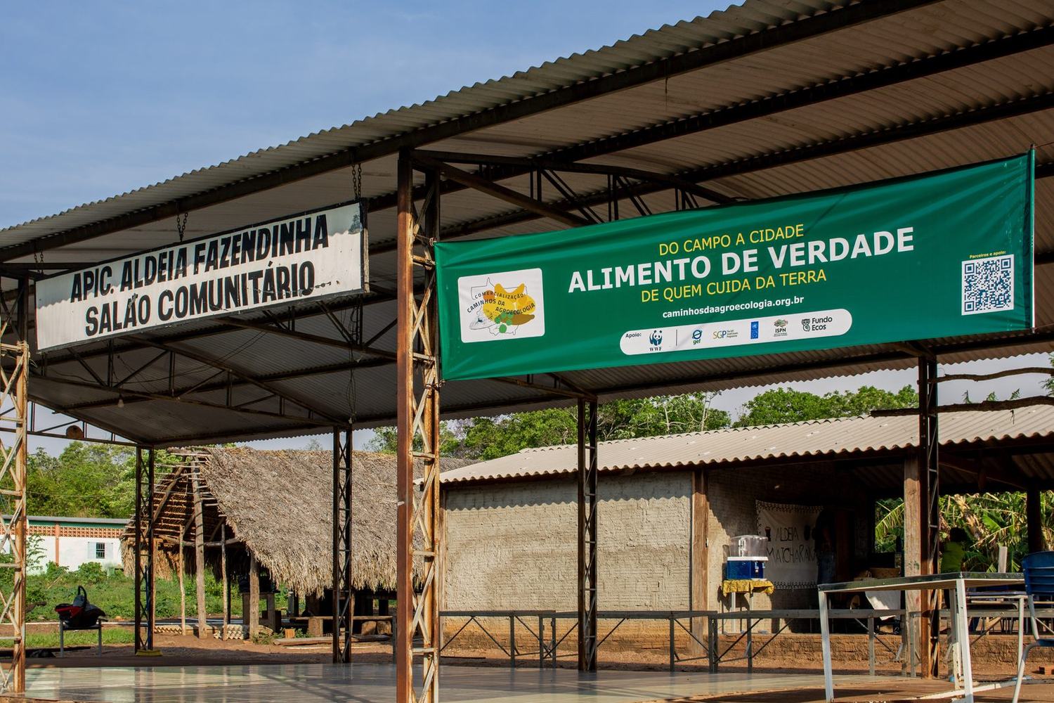 Salão comunitário da APIC na Aldeia Fazendinha, com a faixa da Rota Caminhos da Agroecologia: do campo à cidade, alimento de verdade de quem cuida da terra
