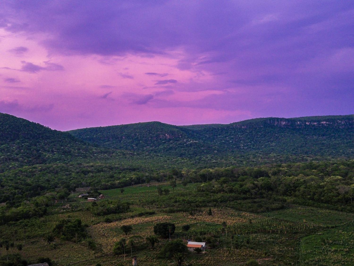 Céu lilás de fim de tarde chuvoso sobre a serra e as roças da Terra Indígena