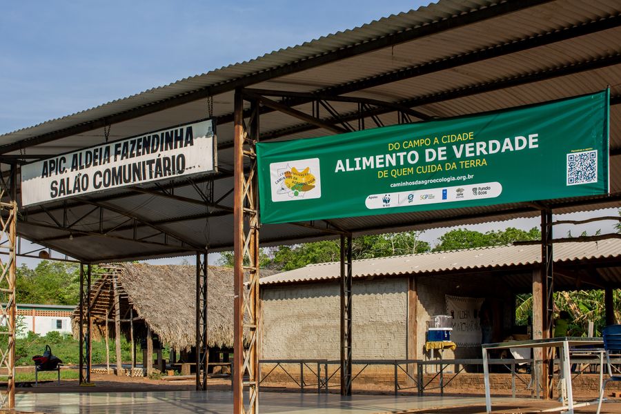 Salão comunitário da APIC, na Aldeia Fazendinha, com a faixa da Rota Caminhos da Agroecologia estendida para a Feira de Roças e Quintais