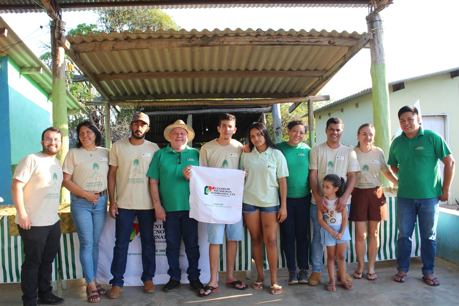 Equipe do CTA reunida em foto no Centro Social da Bocaina, com Vilmon Alves Ferreira, presidente do CTA, segurando a sacola do CTA