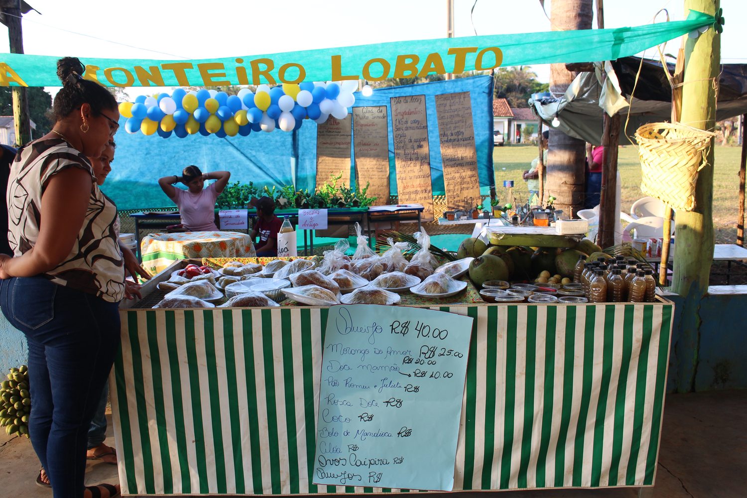 Barraca da Escola Monteiro Lobato com quitandas, cocos e mel