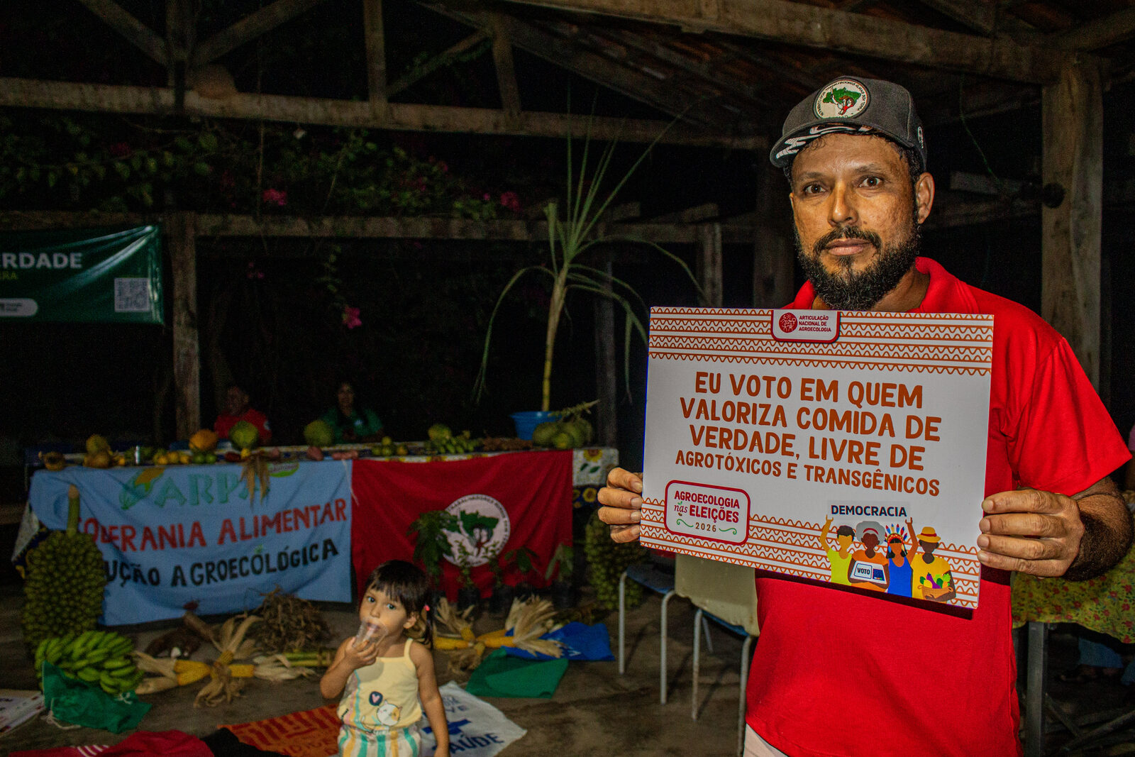 Agricultor segurando placa da campanha Agroecologia nas Eleições com a frase sobre comida de verdade, livre de agrotóxicos e transgênicos