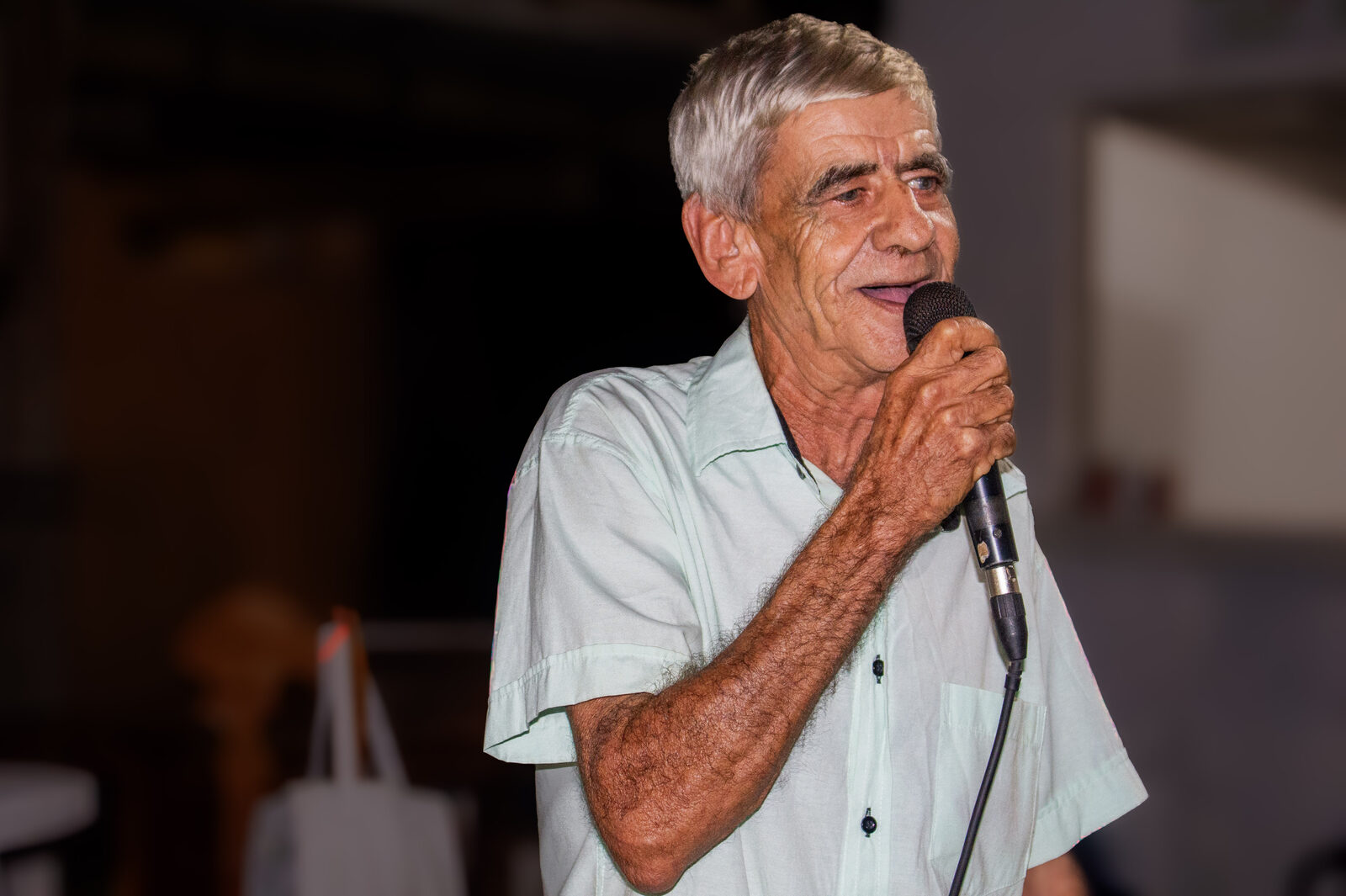 Morador do assentamento fala ao microfone no encerramento da feira