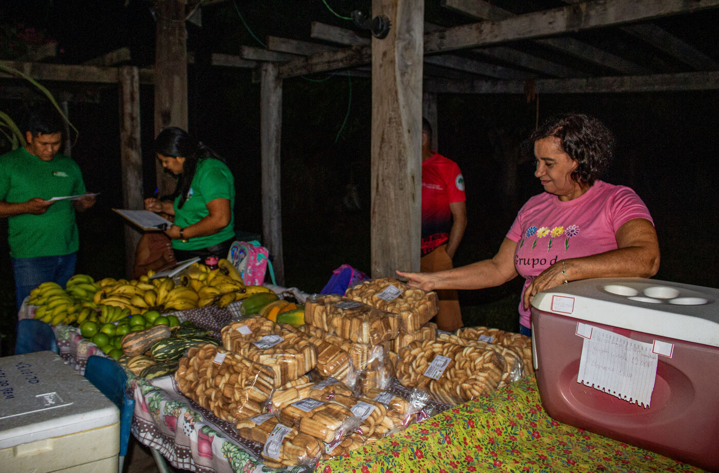 Agricultoras atendendo na banca de panificados e frutas