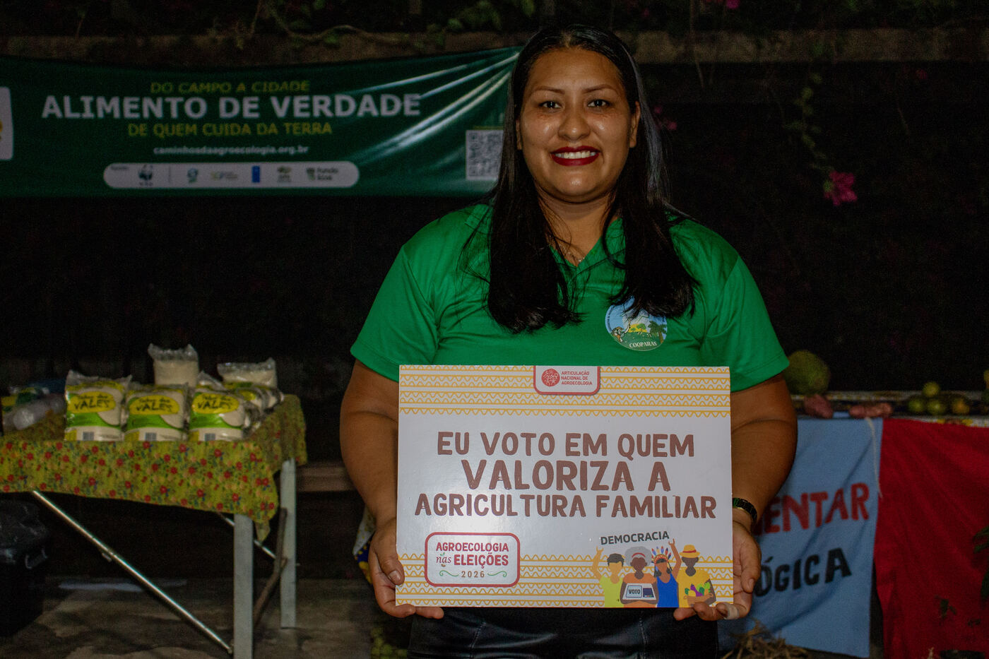 Agricultora com placa da campanha em defesa da agricultura familiar