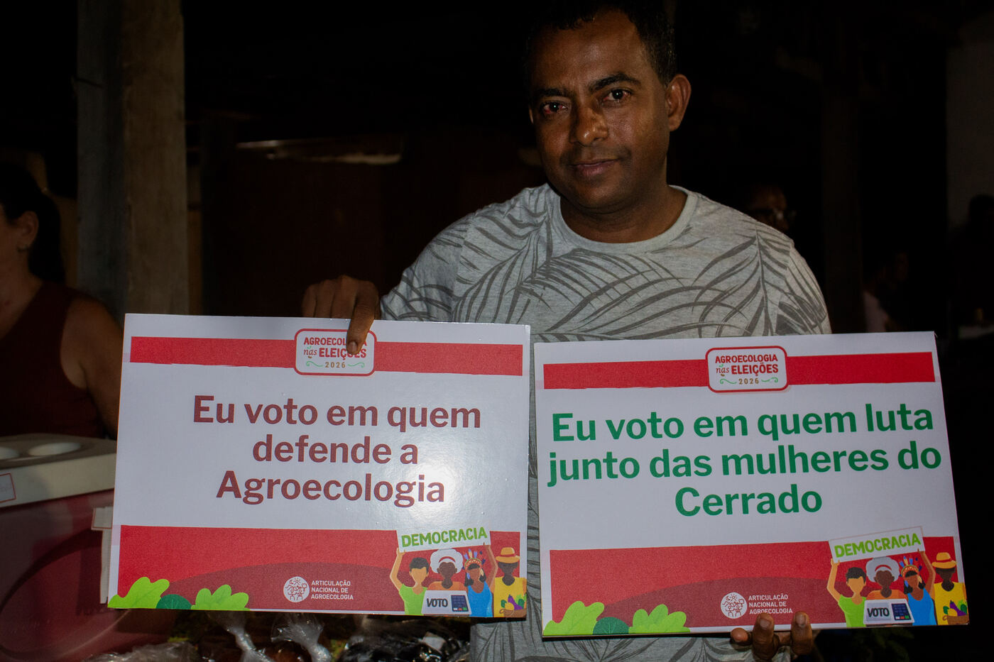 Agricultor com placas em defesa da agroecologia e das mulheres do Cerrado