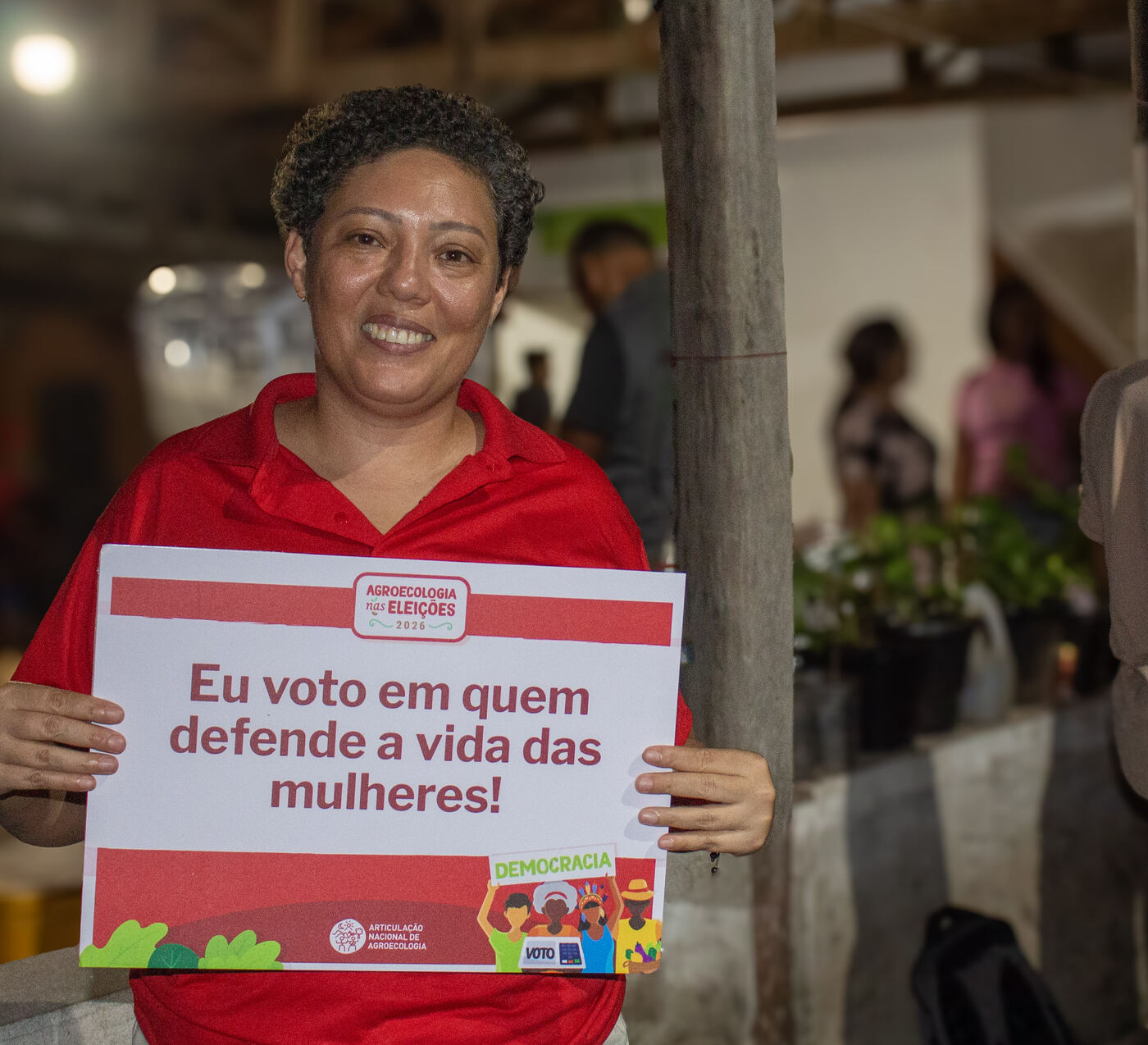 Agricultora com placa em defesa da vida das mulheres