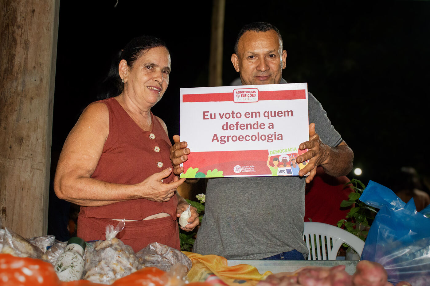 Casal de agricultores na banca durante a noite da feira
