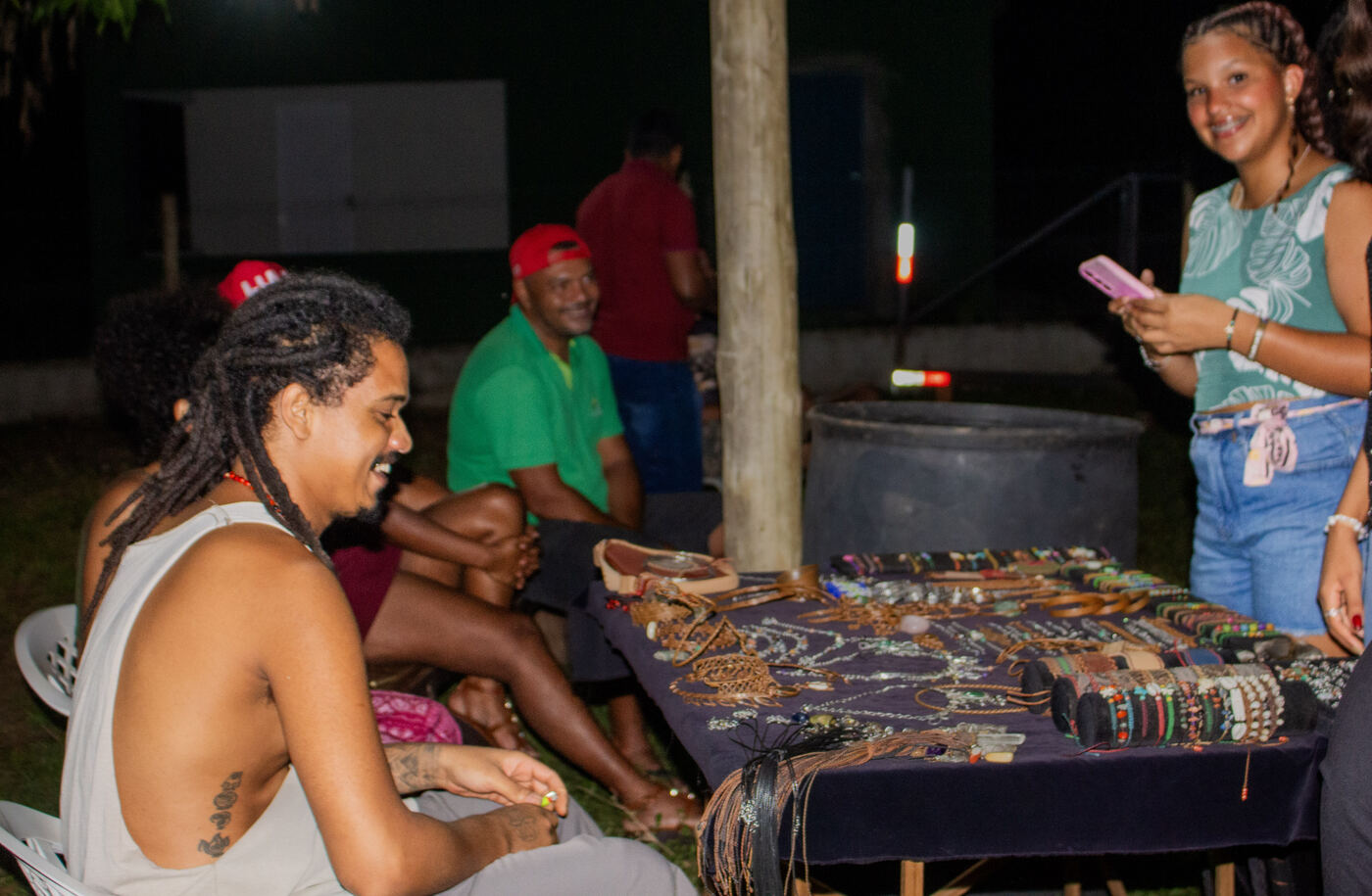 Artesã apresentando biojoias e peças de artesanato na feira