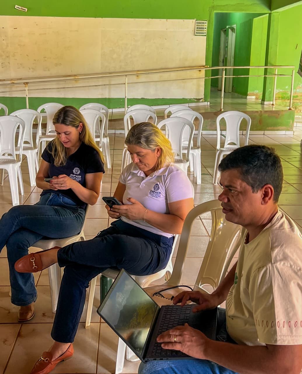Rafaela e Loana, da EMPAER, sentadas com o celular na mão, e Ronaldo, do CTA, com o computador no colo