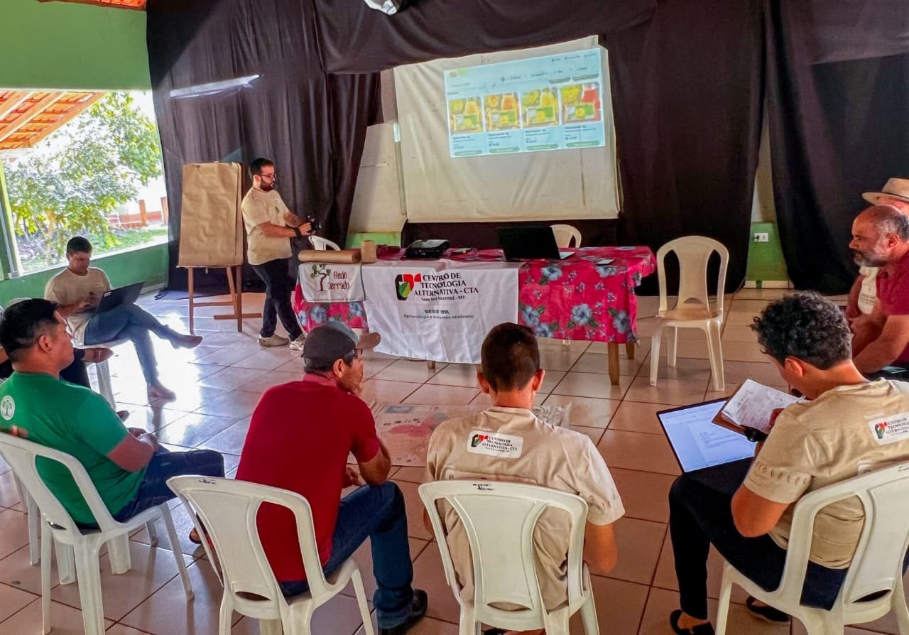 Participantes com computadores testando o Balaio, com a projeção do sistema ao fundo