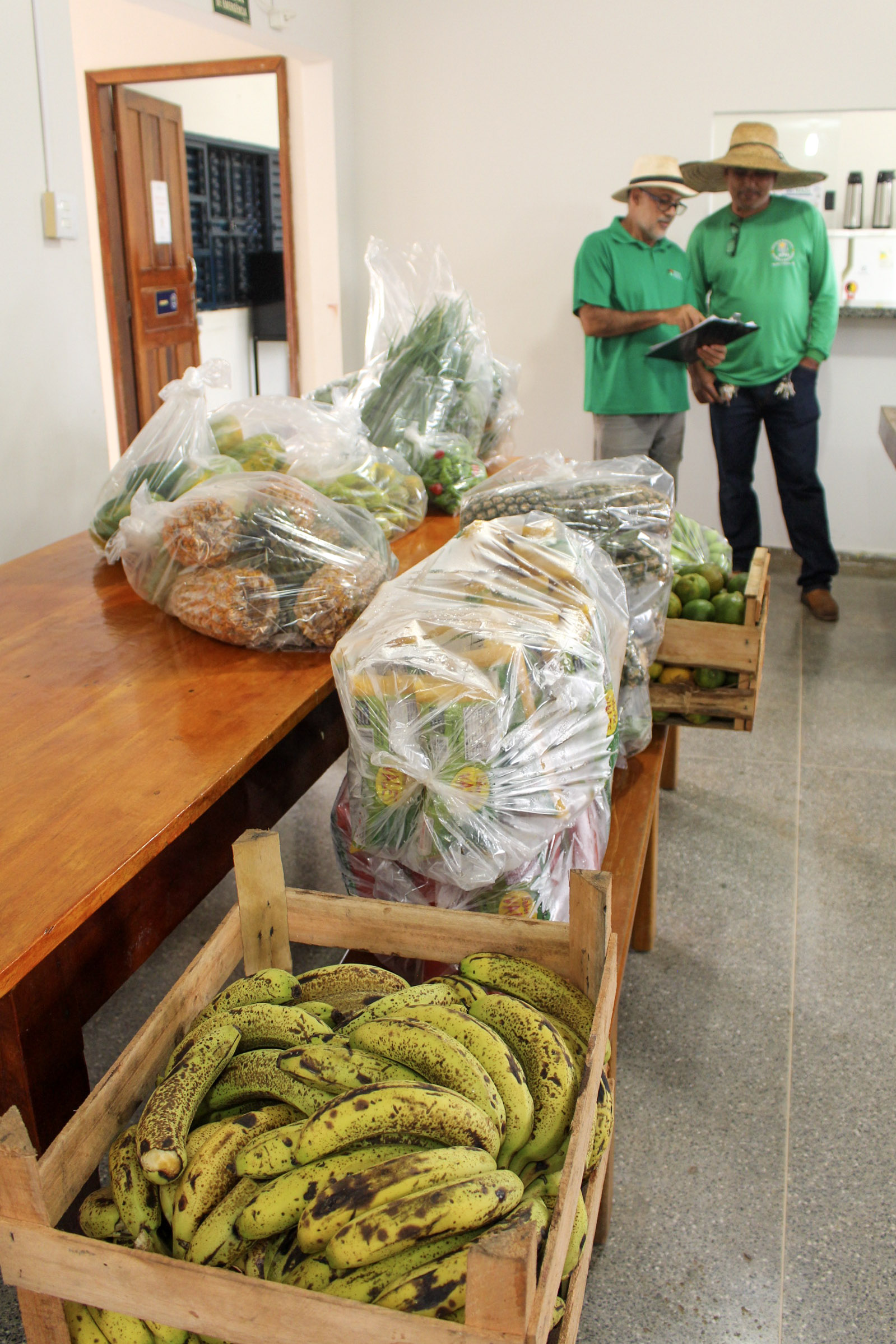 Conferência dos alimentos entregues na APAE — técnicos registrando os produtos no recebimento