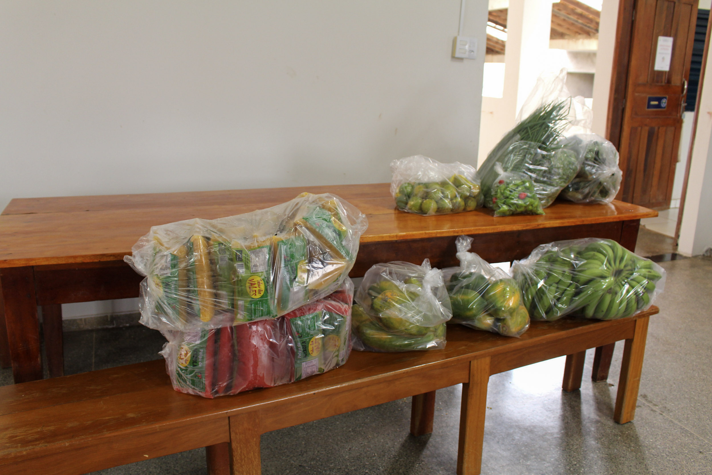 Equipe recebendo os alimentos do PAA no corredor da APAE de Pontes e Lacerda