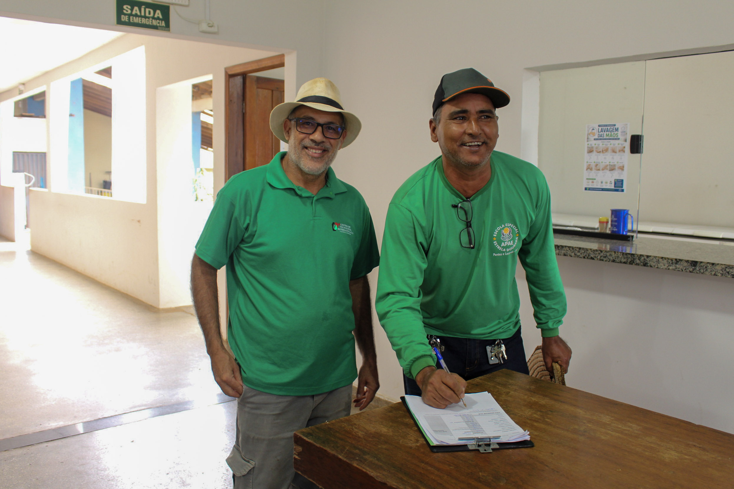Ronaldo Adriano Faria e colega registrando a entrega dos alimentos na APAE